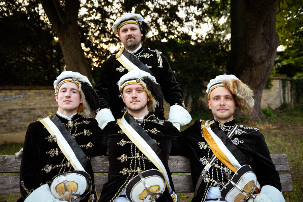 4 Männer in traditioneller studentischer Uniform.